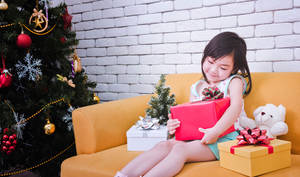 Girl With Christmas Present Wallpaper