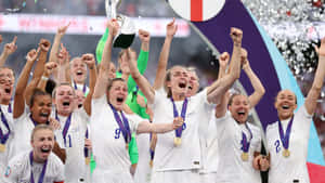 Girls Soccer Team Celebrating Victory With Trophy Wallpaper