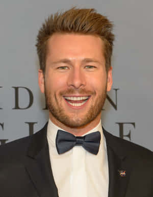 Glen Powell Smilingin Tuxedo Wallpaper