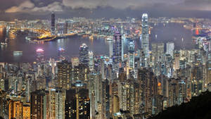 Glittering Cityscape Glows Under Night Sky. Wallpaper