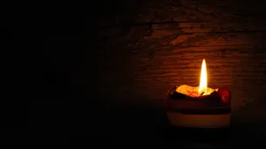 Glowing Candlein Darkness Wallpaper