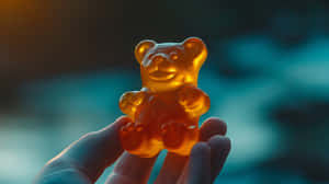 Glowing Gummy Bear Held Aloft Wallpaper