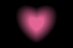 Glowing Heart Against Black Background Wallpaper