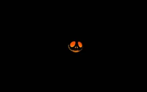 Glowing Jack O Lantern Faceon Black Background Wallpaper