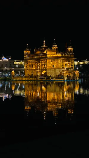 Golden Temple Lit Up At Night Wallpaper