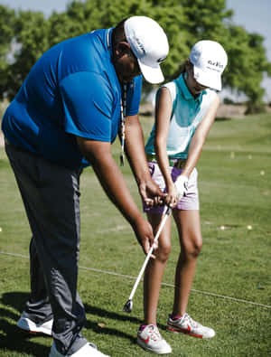 Golf Instructor Guiding Young Player Wallpaper