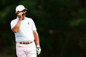 Golfer Adjusting Sunglasseson Course Wallpaper