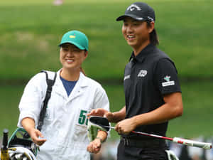 Golferand Caddie Smiling During Tournament Wallpaper