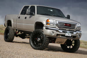 Gray Jacked Up Trucks In The Desert Wallpaper