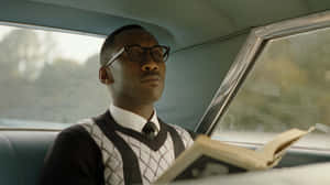 Green Book Character Readingin Car Wallpaper