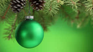 Green Christmas Ball Hanging On A Pine Tree Branch Wallpaper