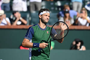 Grigor Dimitrov In Action On A Tennis Court. Wallpaper