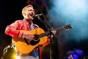 Guitarist Singingon Stage Wallpaper