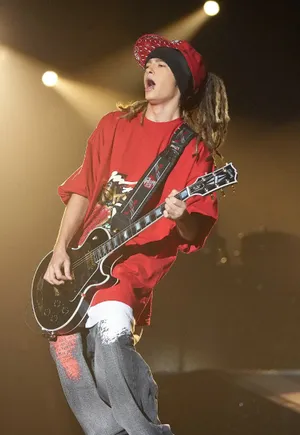 Guitaristin Red Performingon Stage Wallpaper