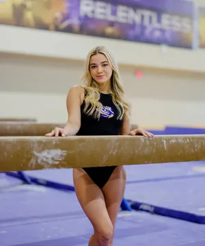 Gymnast Posingon Balance Beam Wallpaper