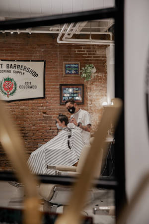 Hairdresser Performing Haircut On Client Wallpaper