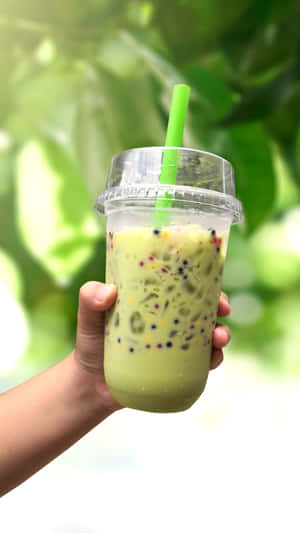 Hand Holding Boba Tea Green Background.jpg Wallpaper