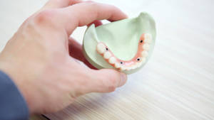 Hand Holding Full Bottom Implant Dentistry Wallpaper