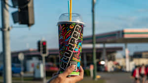 Hand Holding Slurpee Cup Outdoors Wallpaper