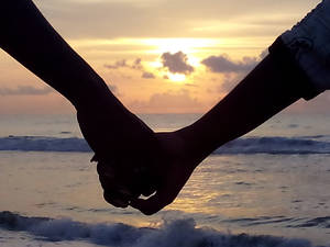 Hand In Hand Facing Ocean Wallpaper