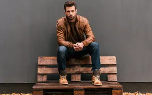 Handsome Man Sitting On Bench Wallpaper