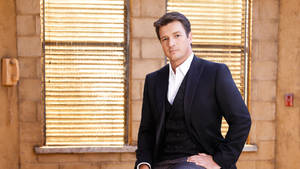 Handsome Nathan Fillion In Black Suit Wallpaper