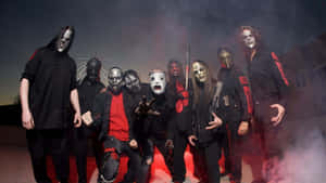 Heavy Metal Band Slipknot In Dark Attire Performing On Stage Wallpaper