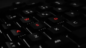 High-end Gaming Laptop With Red-labeled Wasd Keyboard Wallpaper