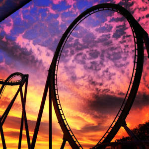 High-flying Thrill On A Roller Coaster Amidst Vibrant Sunset Wallpaper