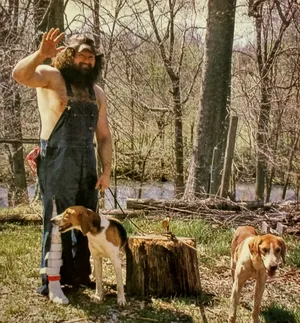 Hillbilly Jim Waving With Dogs Outdoors Wallpaper