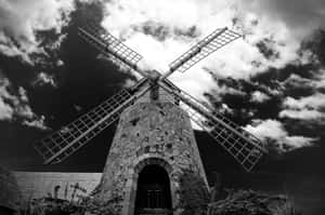 Historic Windmill Against Cloudy Sky Wallpaper