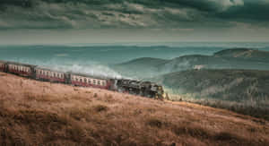 Hogwarts Express Steaming Through Scenic Landscape Wallpaper