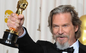 Hollywood Legend Jeff Bridges Holding His Trophy Proudly Wallpaper