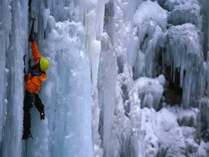 Ice Climber Ascending A Frozen Waterfall Wallpaper