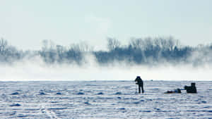 Ice Fishing Enthusiast On A Frozen Lake Wallpaper