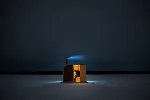 Ice Fishing On A Frozen Lake With A Snowy Background Wallpaper