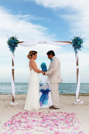 Idyllic Beach Wedding With Sunset Backdrop Wallpaper