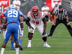 Ikem Ekwonu Bending On Football Field Wallpaper