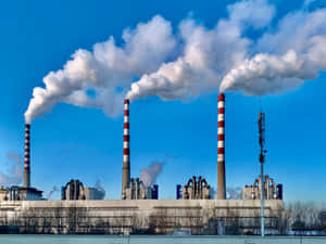 Industrial Smokestacks Emitting Smoke Wallpaper