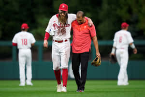 Injured Baseball Player Assisted Off Field Wallpaper