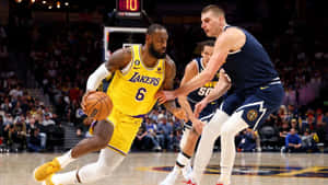 Intense Basketball Matchup Lakersvs Nuggets Wallpaper