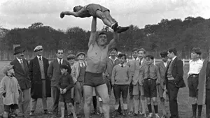 Italian Professional Boxer Primo Carnera Lifting A Man Wallpaper