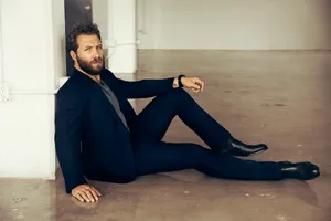 Jai Courtney Suave Suit Pose Wallpaper