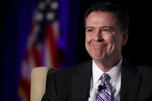 James Comey Smilingwith American Flag Background Wallpaper