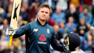 Jason Roy Posing With A Lion Logo Wallpaper