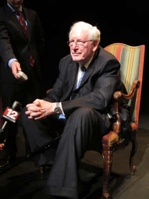 Jay Rockefeller Sitting On Colorful Chair Wallpaper