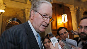 Jay Rockefeller Speaking Into Recording Devices Wallpaper