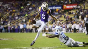 Jayden Daniels Evading Tackle During Game Wallpaper