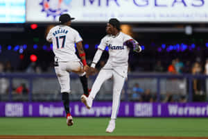 Jazz Chisholm Jr Celebratory Jump With Teammate Wallpaper