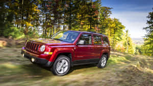 Jeep Patriot Cruising Through Rugged Terrain Wallpaper